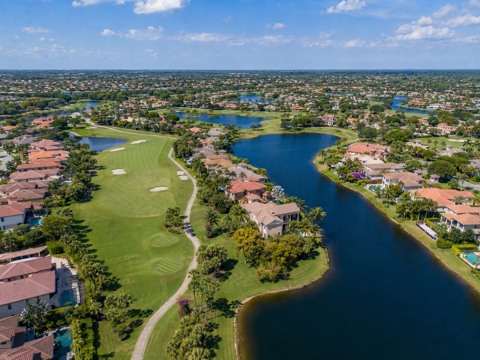 An aerial view of a community laid out around a golf course and waterways
